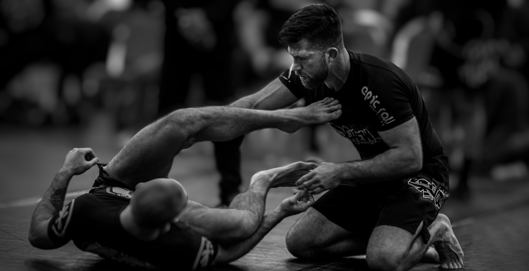 Chewy engaged in a grappling match on a mat.